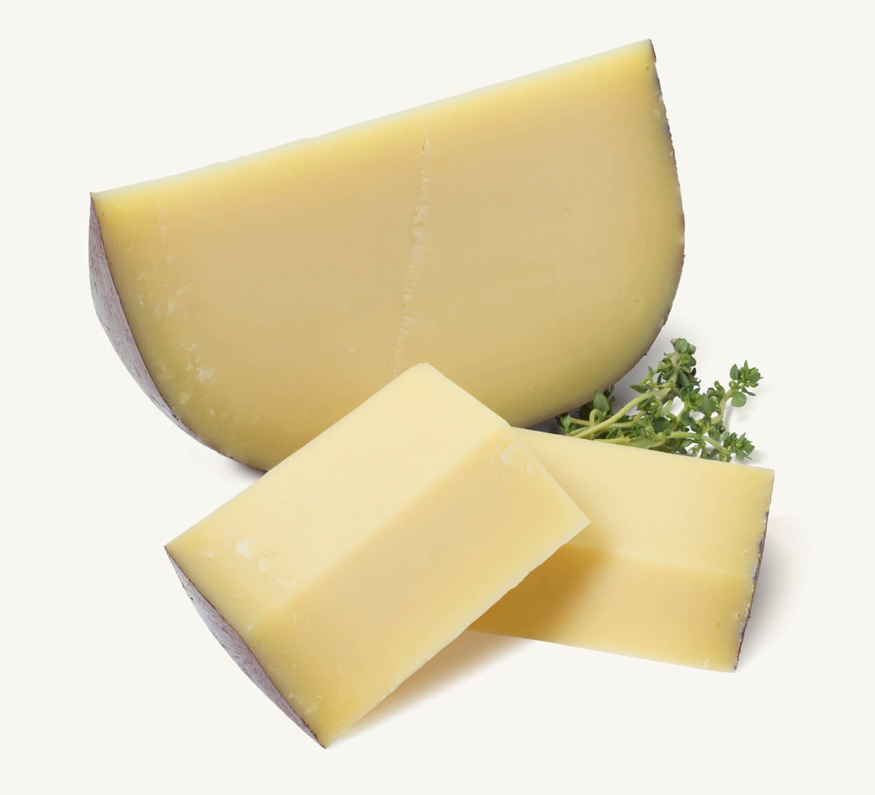 Trozo de queso sardo y dos cortes rectangulares acompañado de ramitas de tomillo fresco