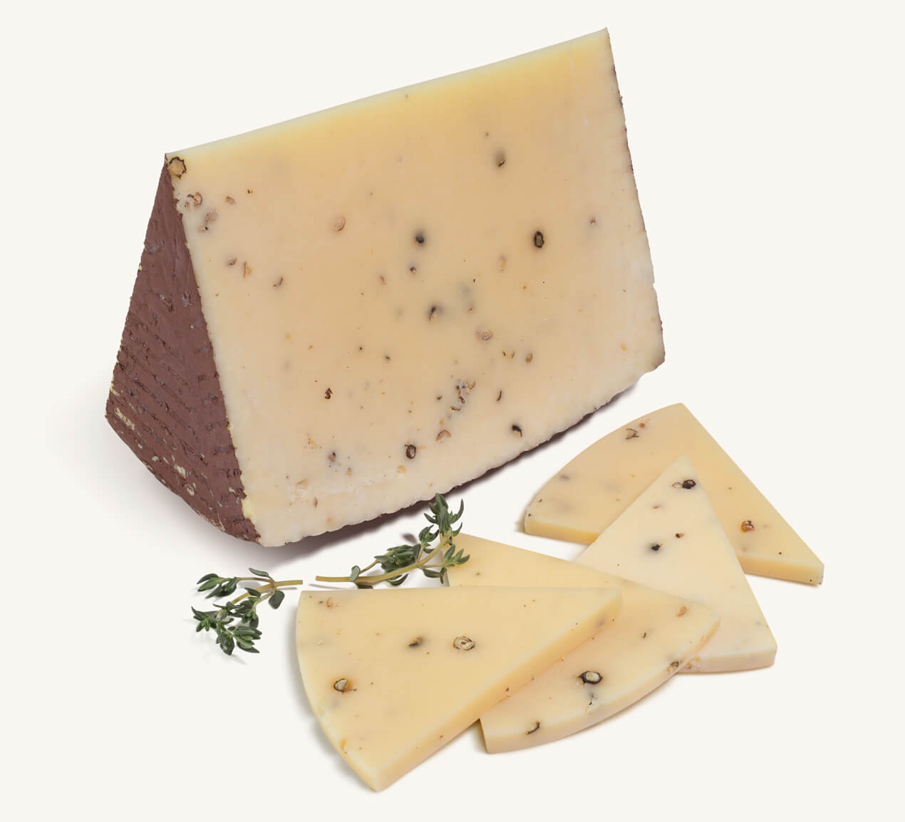 Trozo de queso Canestrato con granos de pimienta negra, acompañado de rebanadas finas y ramitas de tomillo