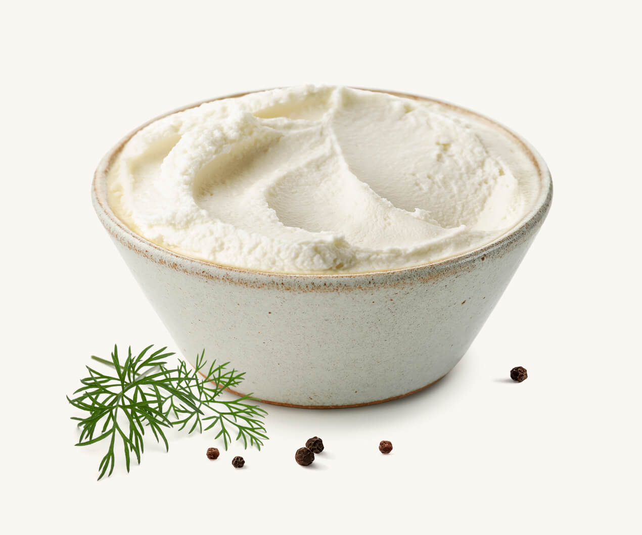Pote de queso crema light acompañado de ramita de eneldo y granos de pimienta