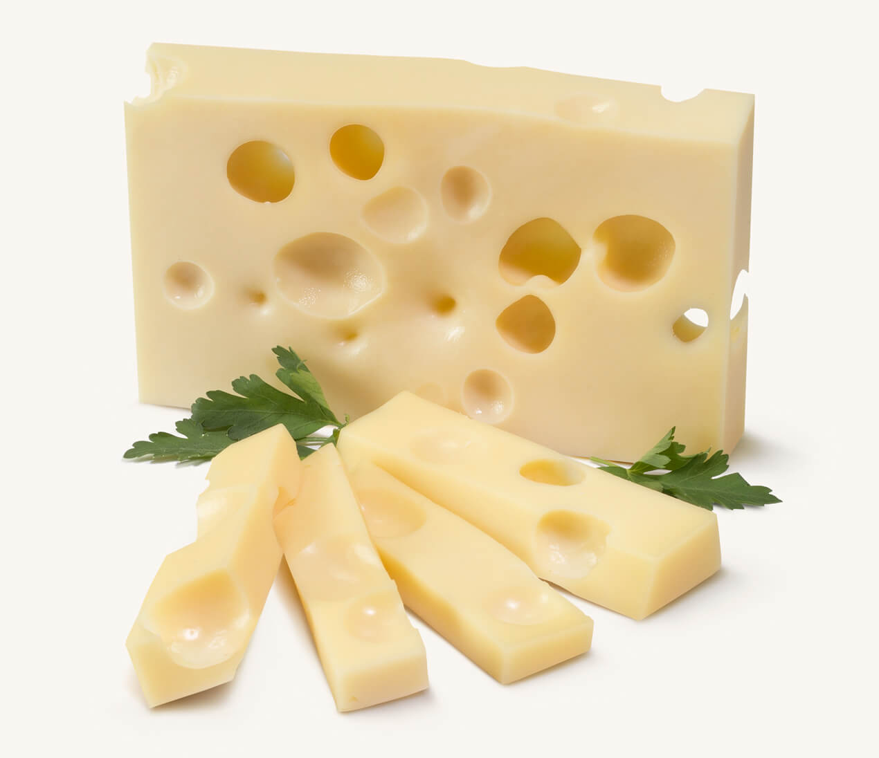 Trozo de queso gruyere con agujeros, con bastones del mismo queso y perejil