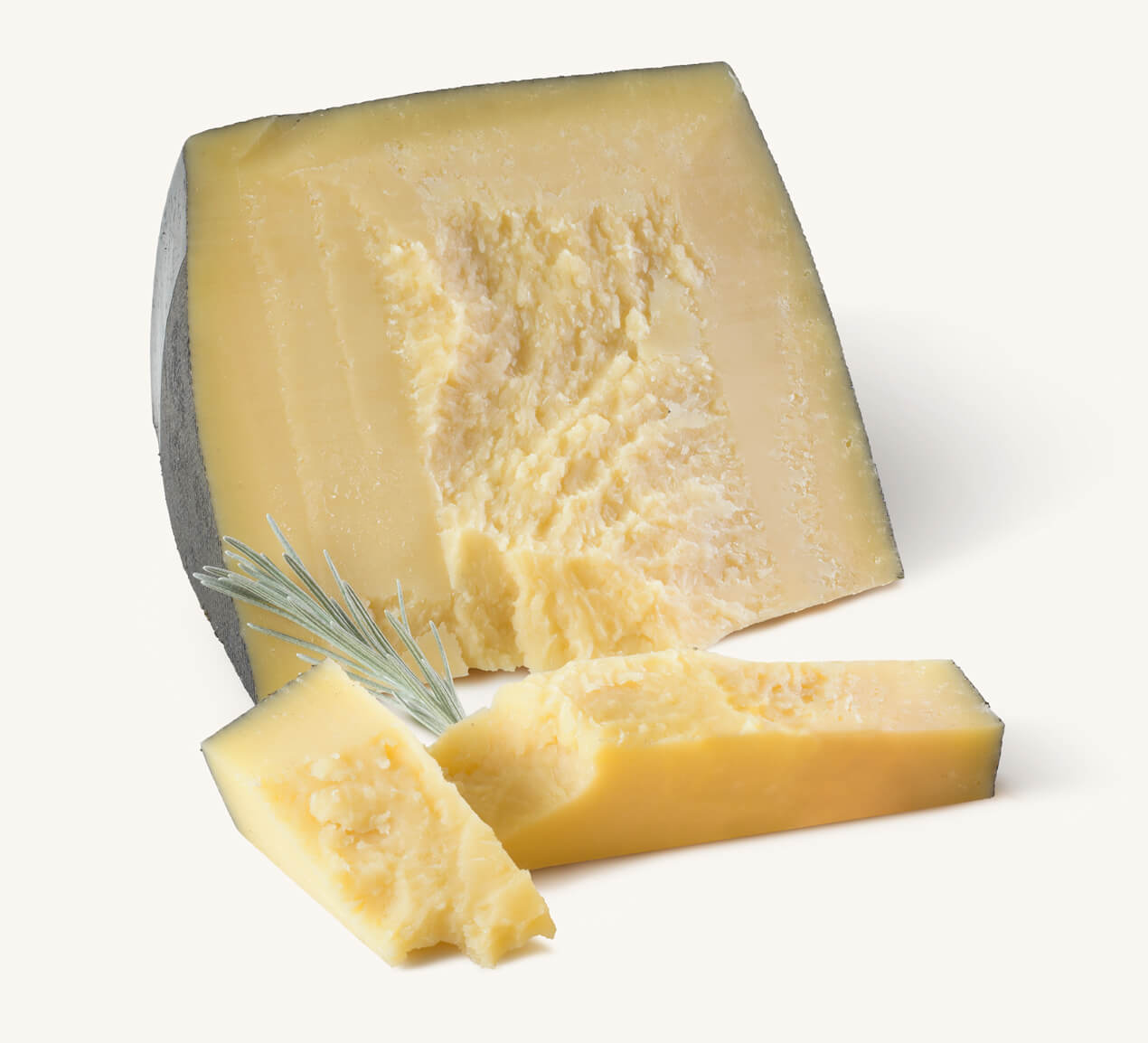Trozo de queso romano con cortes rectangulares y ramita de romero